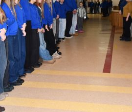 Mokiniai ir darbuotojai gieda himną