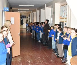 Mokiniai ir darbuotojai gieda himną